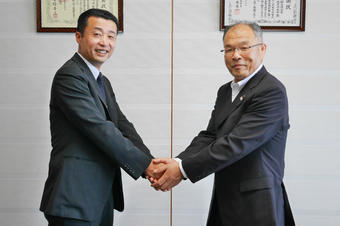 岐阜県産青果物の販売拡大に向け、握手を交わす藤井社長(左)と西村県本部長(右)の内容を表示